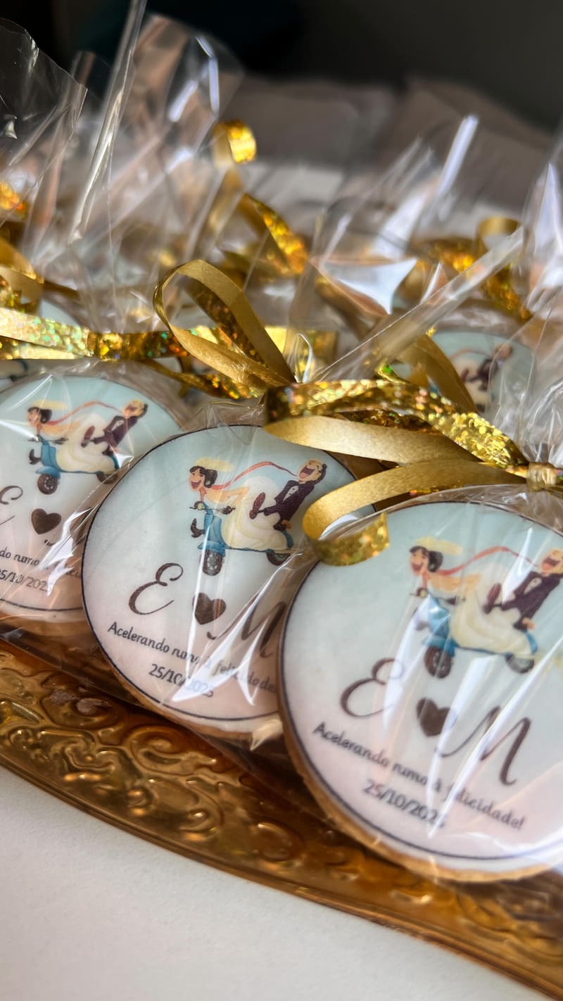 Lembranças de casamento: biscoitos redondos com ilustração dos noivos, embalados com laço dourado