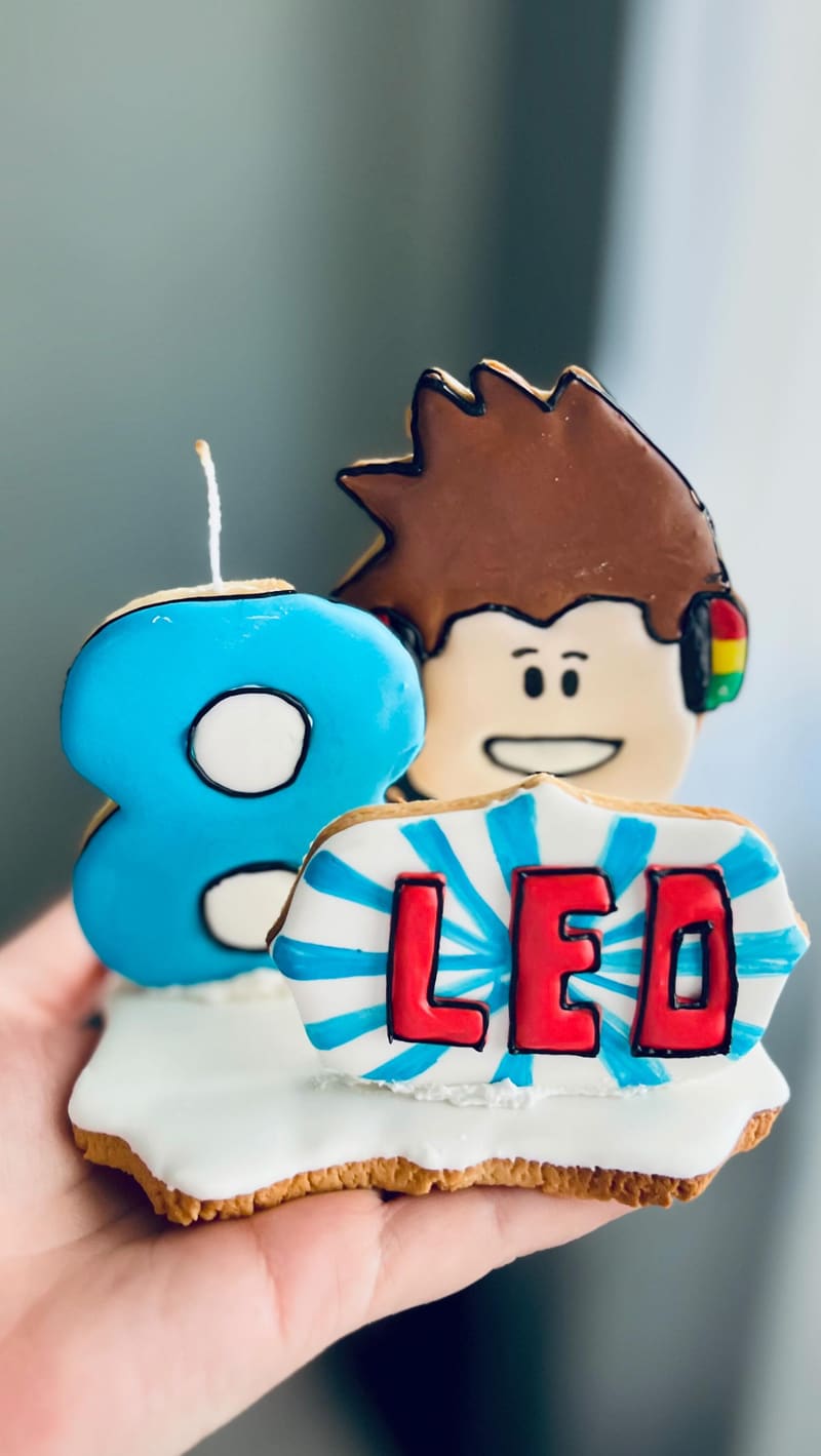 Biscoito grande em formato do número 8 com o nome Leo e o desenho de um menino